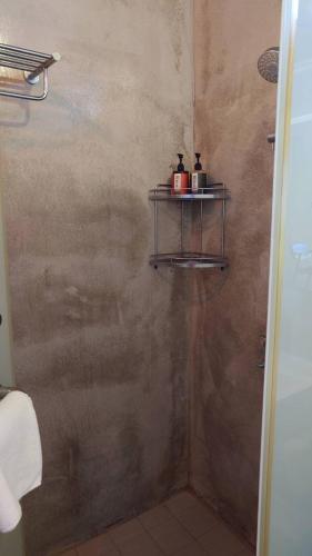 a bathroom with a shower with a shelf on the wall at 山海高台民宿 M&S nature view house in Chenggong