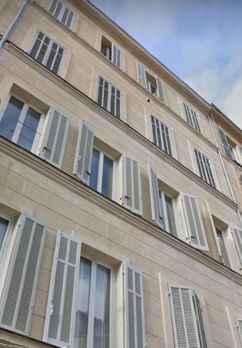 - un bâtiment avec des fenêtres blanches et des volets dans l'établissement Marseille Longchamp, à Marseille