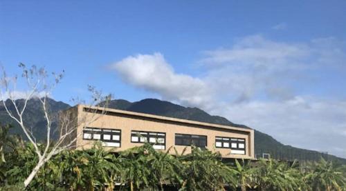 a building with a mountain in the background at 山海高台民宿 M&S nature view house in Chenggong