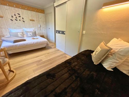 a hotel room with two beds and a closet at Hôtel La Rencluse in Luchon
