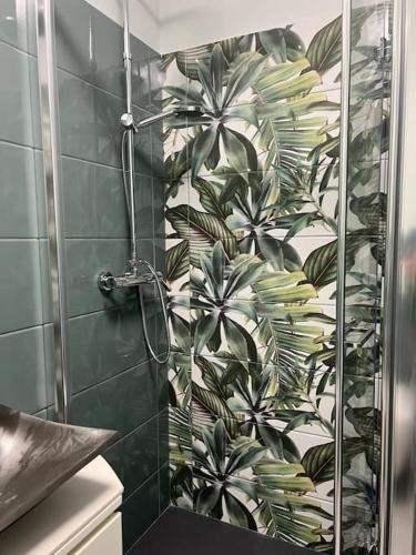 une salle de bain avec douche avec un papier peint vert et blanc dans l'établissement Nuovo appartamento vista mare, à Roquebrune-Cap-Martin