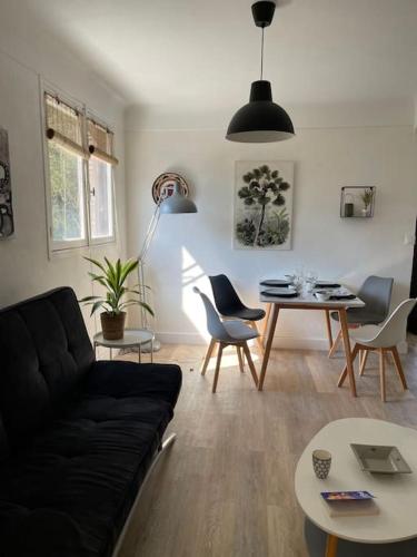 un salon avec un canapé noir et une table dans l'établissement Saint Aygulf près de la plage, à Fréjus