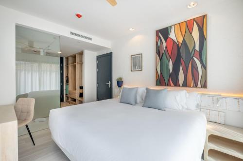 a white bedroom with a large white bed and a table at Hotel Cetina Cabo de Palos Puerto in Cabo de Palos
