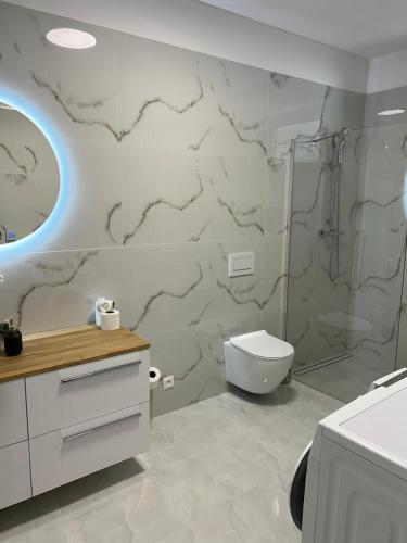 a white bathroom with a toilet and a shower at Apartmán VAJANA Exclusiv & Jacuzzi in Piešťany