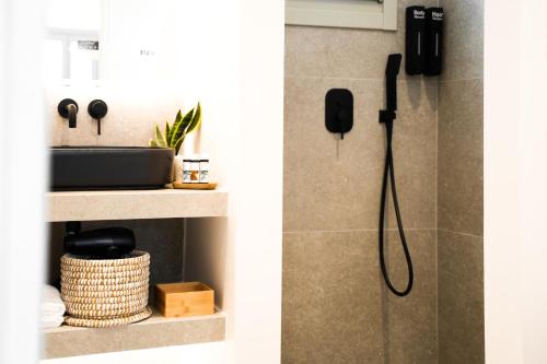 a shower in a bathroom with a phone on the wall at Apademia Skyros Luxury Residences in Skiros