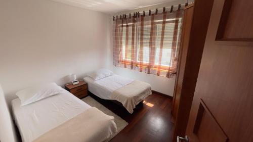 a small bedroom with two beds and a window at Lorena Apartment in Šibenik