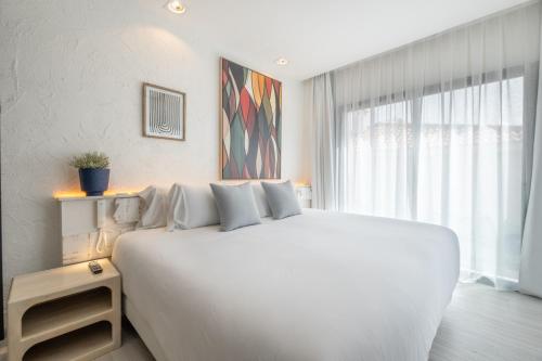 a white bed in a room with a large window at Hotel Cetina Cabo de Palos Puerto in Cabo de Palos