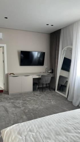 a hotel room with a bed and a flat screen tv at Готель VinoGrad 2й корпус in Haysyn