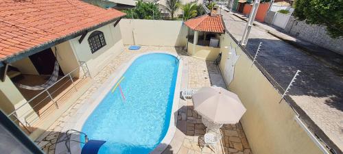 Una vista aérea de una piscina con una sombrilla. en Conforto e Diversão em Ponta Neg, Casa com Piscina, Próxima à Praia e Comodidades Completa, en Natal