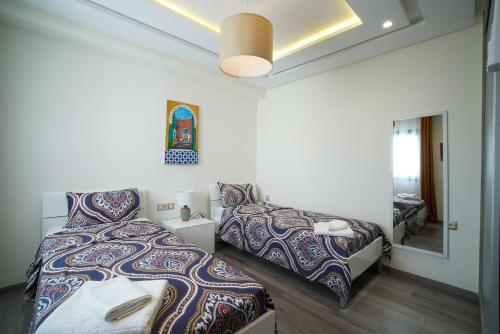 een slaapkamer met twee bedden en een spiegel bij Northview Properties in Tanger
