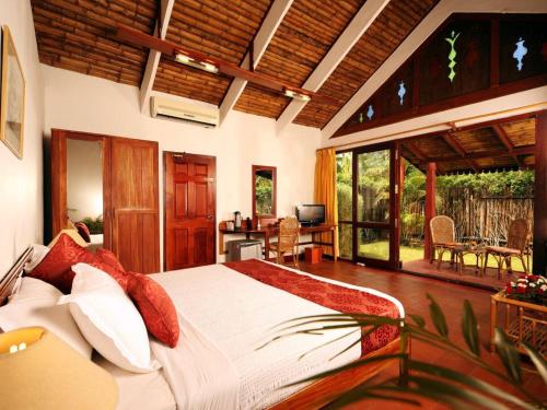 a bedroom with a large bed in a room at Abad Whispering Palms in Kumarakom