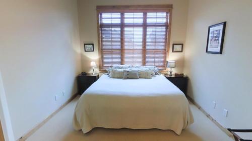 een slaapkamer met een groot bed en een raam bij This Townhouse In Legends On Bridger Creek Development Is Beautifully Finished in Bozeman