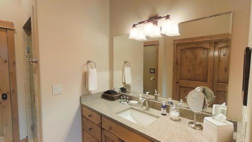 een badkamer met een wastafel en een grote spiegel bij This Townhouse In Legends On Bridger Creek Development Is Beautifully Finished in Bozeman
