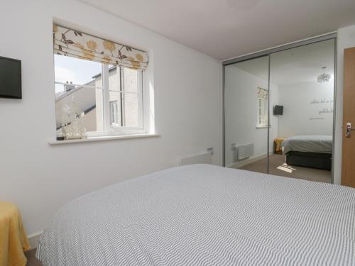 a white bedroom with a bed and a window at Ingle View in Carnforth