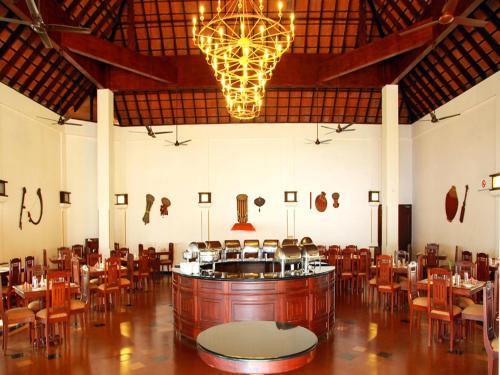 a large room with a bar and tables and chairs at Abad Whispering Palms in Kumarakom