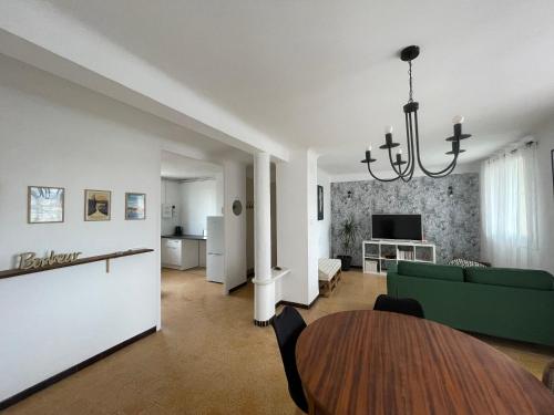 un salon avec un canapé vert et une table dans l'établissement Appartement de Florent, à Arles