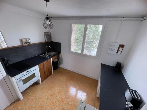une petite cuisine avec un évier et une cuisinière dans l'établissement Appartement de Florent, à Arles