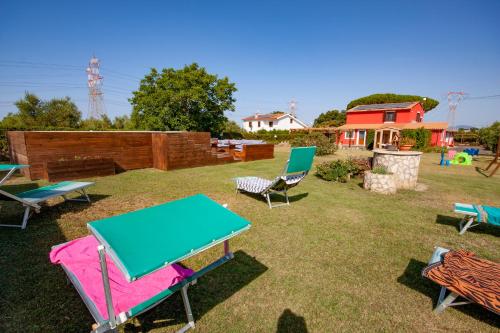 a group of picnic tables and chairs in a yard at Agriturismo L'Istrice di Giò in Montalto di Castro
