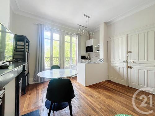 une cuisine avec une table et des chaises dans une pièce dans l'établissement SCI Les Petits Blés, à Chartres