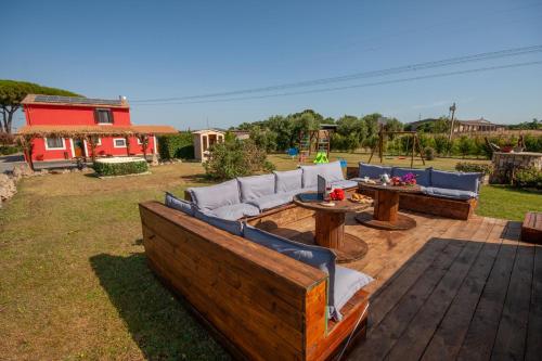 a patio with couches and tables and a playground at Agriturismo L'Istrice di Giò in Montalto di Castro