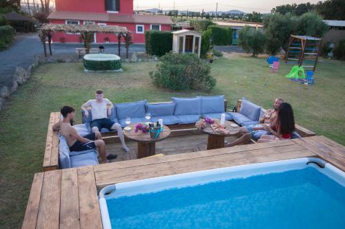 a group of people sitting in chairs around a pool at Agriturismo L'Istrice di Giò in Montalto di Castro