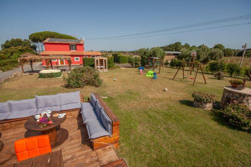a view of a backyard with a couch and a playground at Agriturismo L'Istrice di Giò in Montalto di Castro