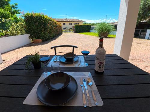 a table with a bottle of wine and a glass at Villa con terrazzo e cortile privato 200m2 pet friendly in Lignana