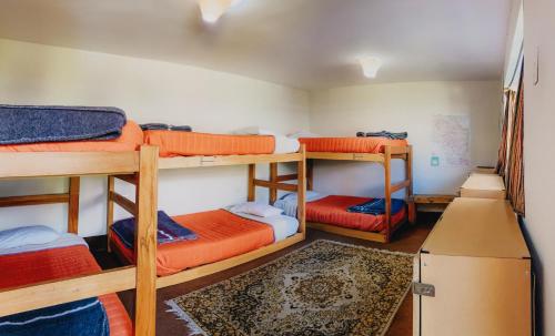 a room with four bunk beds and a refrigerator at Qumir Packers in Huaraz
