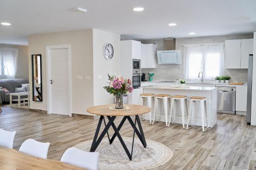 a kitchen and living room with a table with flowers on it at Villa Canela in Illora