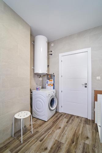 a laundry room with a washing machine and a white door at Villa Canela in Illora