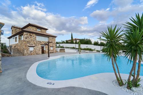 a villa with a swimming pool in front of a house at Villa Canela in Illora