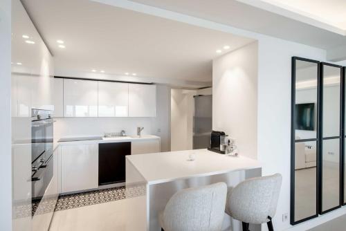 - une cuisine blanche avec un comptoir et des chaises dans l'établissement Charming oasis with terrace 4 BD- 8P - Cannes, à Cannes