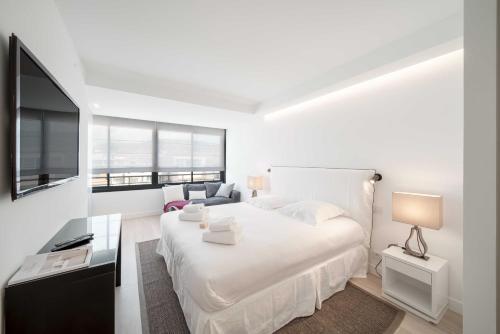 une chambre blanche avec un grand lit et une télévision dans l'établissement Charming oasis with terrace 4 BD- 8P - Cannes, à Cannes
