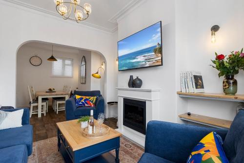 a living room with blue chairs and a fireplace at Maple House - Park View Sleeps 7 in Exeter
