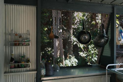 a kitchen with pots and pans hanging from a window at Sometimes Khaoyai in Ban Muak Lek Nai