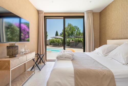 a bedroom with a large bed and a large window at La Villa Monarque in Cap d'Agde