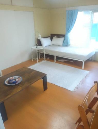 a living room with a couch and a table at EMS Enoshima クラシックゲストハウス 寝室は個室 犬OK in Fujisawa