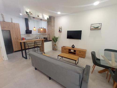 a living room with a couch and a kitchen at Apartamento moderno junto a estación de tren in Córdoba
