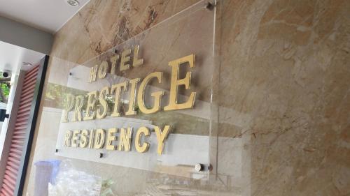 Hotel Prestige Residencyに飾ってある許可証、賞状、看板またはその他の書類