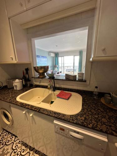 a kitchen with a sink and a large window at Beach Apartment with Stunning View in Can Pastilla
