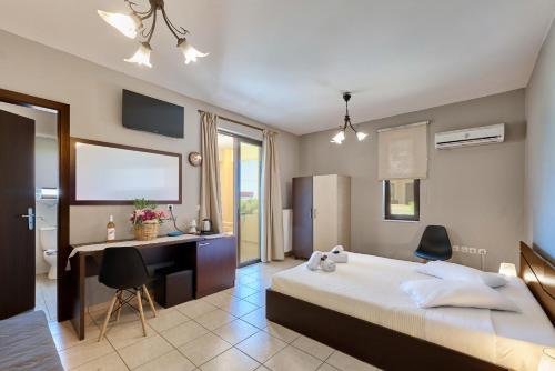 a bedroom with a bed and a desk and a computer at Villa Gereoudis SeaView Apartments-Pool & Bar in Kolymvari