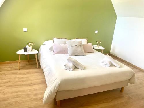 une chambre avec un grand lit blanc avec deux tables dans l'établissement Chez Jacques, à Ruillé-Froid-Fonds