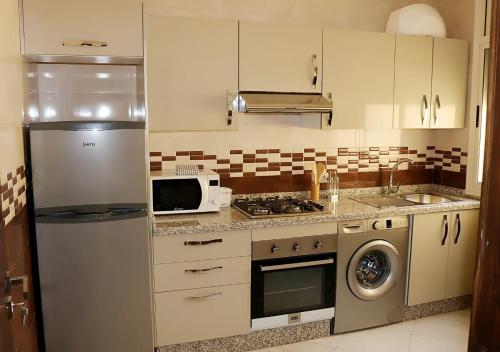 een keuken met een koelkast en een magnetron bij Résidence riad al andalos in Nador