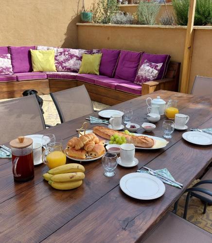 une table en bois recouverte de assiettes de nourriture et de fruits dans l'établissement B&B Maison de Ville Lubersac, à Lubersac