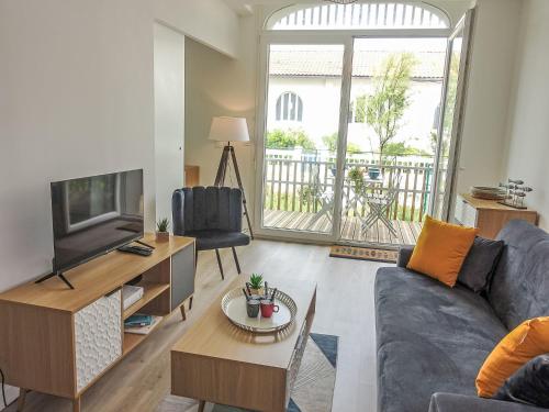 un salon avec un canapé et une télévision dans l'établissement Apartment Cap Océan-8 by Interhome, à Capbreton