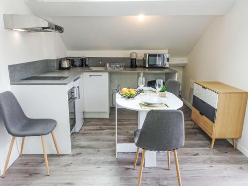 une petite cuisine avec une table et des chaises dans une pièce dans l'établissement Studio Cap Océan-17 by Interhome, à Capbreton