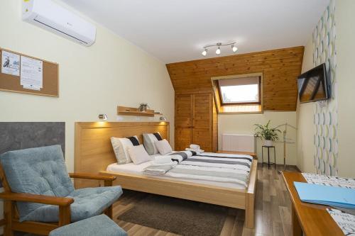 una camera da letto con un letto, una sedia e una scrivania di Ács Apartman a Hévíz