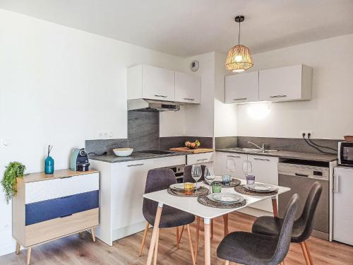 une cuisine avec une table et des chaises dans une cuisine dans l'établissement Apartment Cap Océan-6 by Interhome, à Capbreton