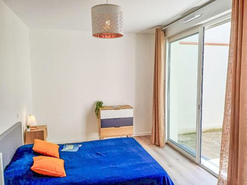 une chambre avec un lit bleu et une grande fenêtre dans l'établissement Apartment Cap Océan-6 by Interhome, à Capbreton