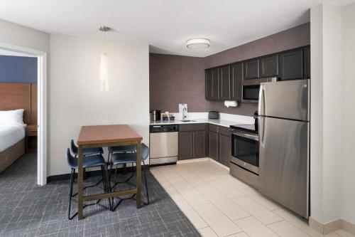 a small kitchen with a table and a refrigerator at Residence Inn by Marriott Lakeland in Lakeland
